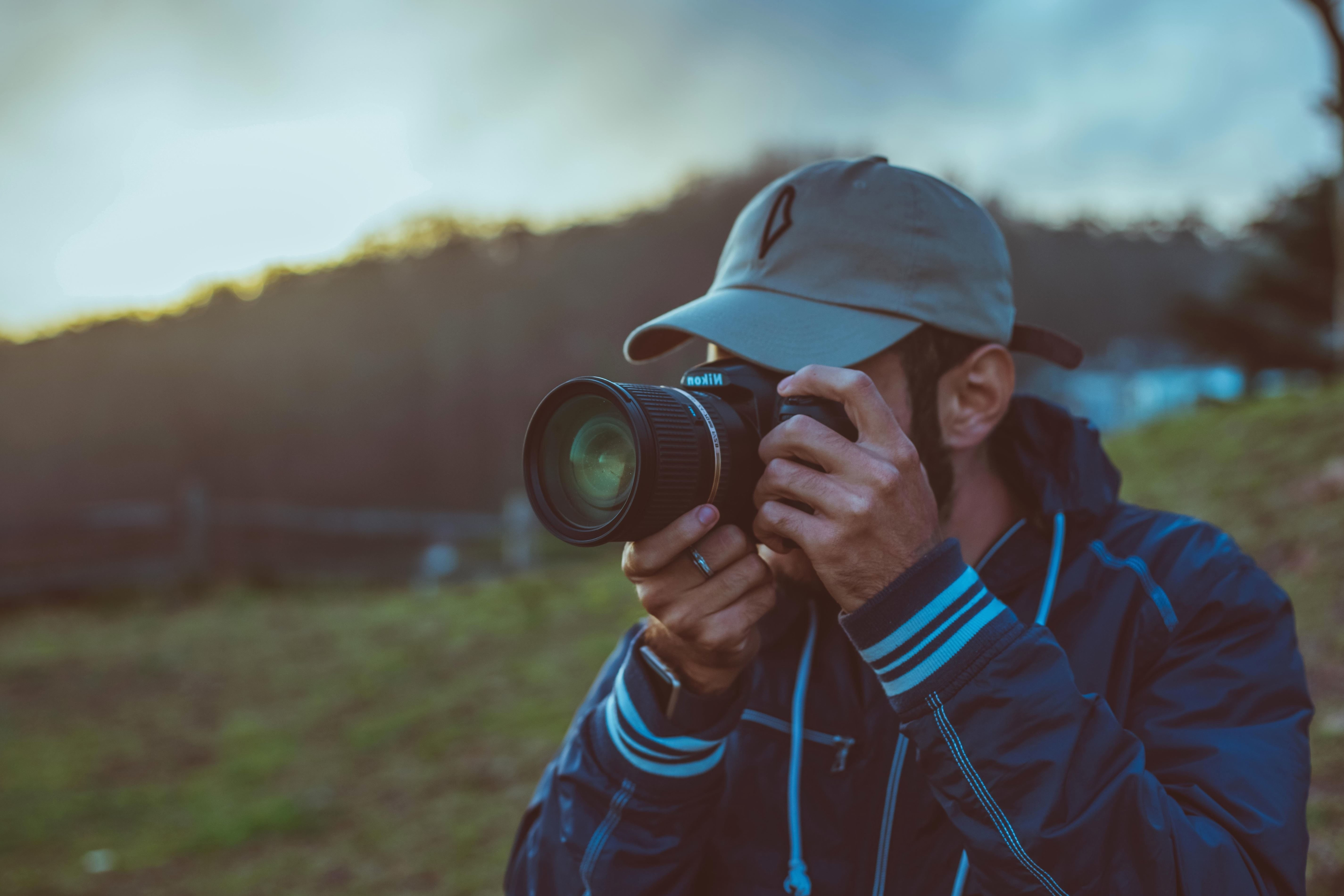 Человек фотографирует другого. Человек с фотоаппаратом. Мужчина с фотоаппаратом. Фотограф с фотоаппаратом. Человек с фотоаппаратом на природе.