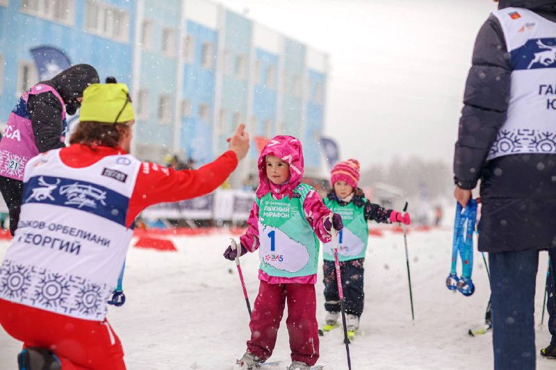 Маленькие дети на лыжах проходят дистанцию детского марафона в Мурманске.