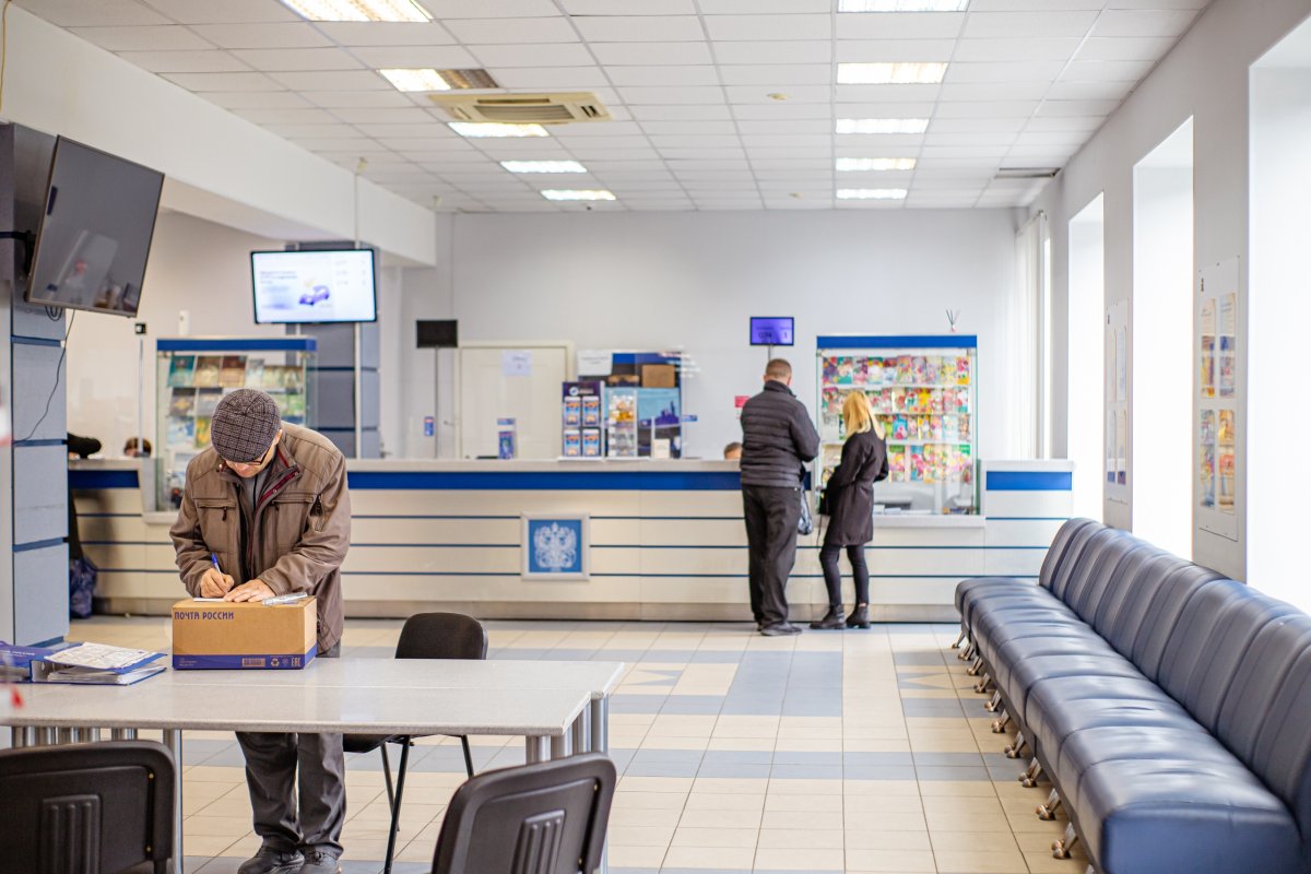 Зал отделения почты в Мурманске с посетителями.