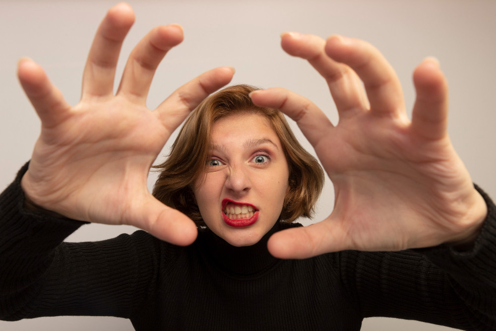 Девушка в черной водолазке ярко демонстрирует эмоции.