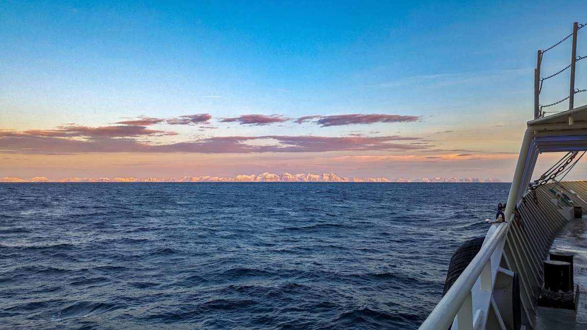 Арктика, море за бором судна, вдали ледяная гряда.