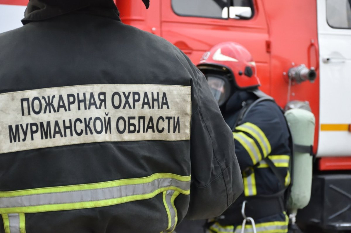 Пожарный стоит у машины.