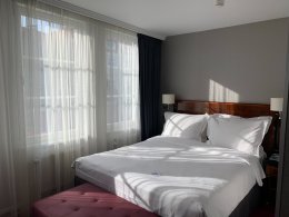 Кровать в отеле на фоне окна