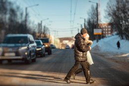 Люди идут по пешеходному переходу.