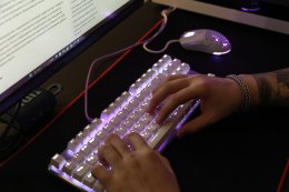 Руки человека, работающего на клавиатуре компьютера.