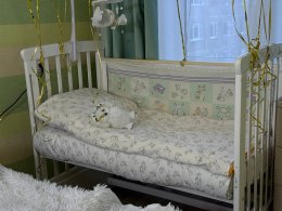 Детская кроватка стоит в комнате.