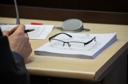 На столе депутата документы, очки.