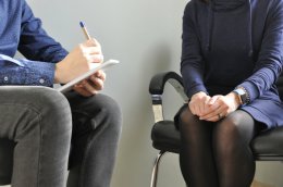 Человек сидит на приёме у психолога.