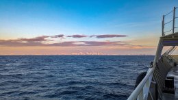 Арктика, море за бором судна, вдали ледяная гряда.