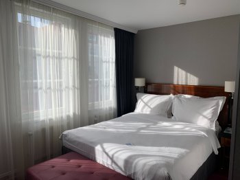 Кровать в отеле на фоне окна