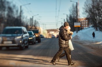 Люди идут по пешеходному переходу.