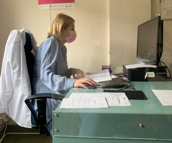 Врач сидит за компьютером