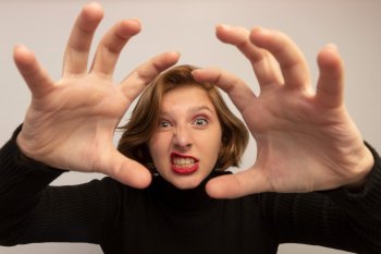 Девушка в черной водолазке ярко демонстрирует эмоции.