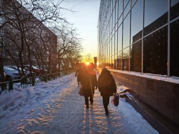 Улица Ленинградская, тротуар вдоль торгового центра "Волна". Идут люди, светит солнце зимой.