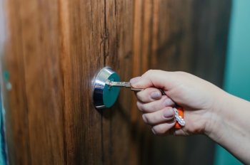 Человек открывает дверь ключом.