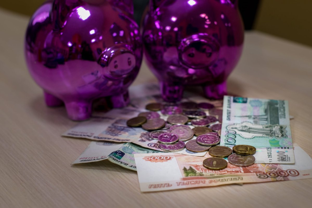 Рубли лежат возле свиньи-копилки