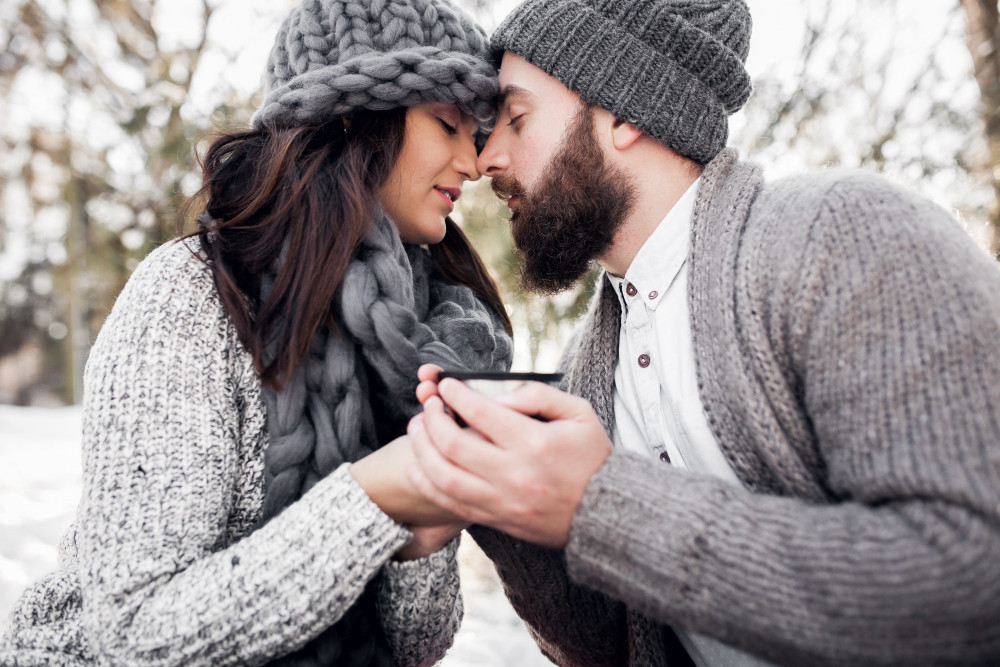 Мужчина и женщина обнимаются на улице, держа одну чашку