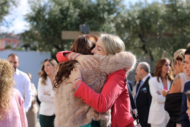 две женщины обнимаются в толпе