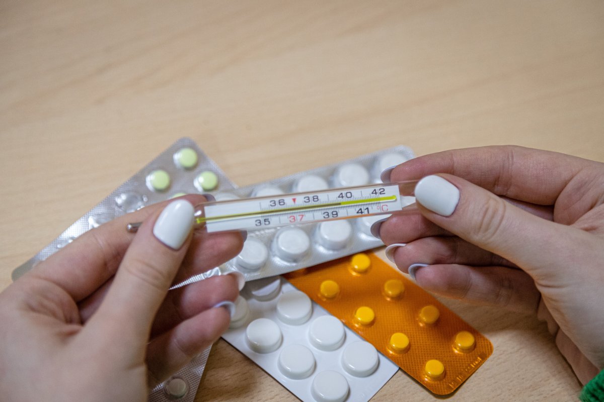 Девушка держит градусник