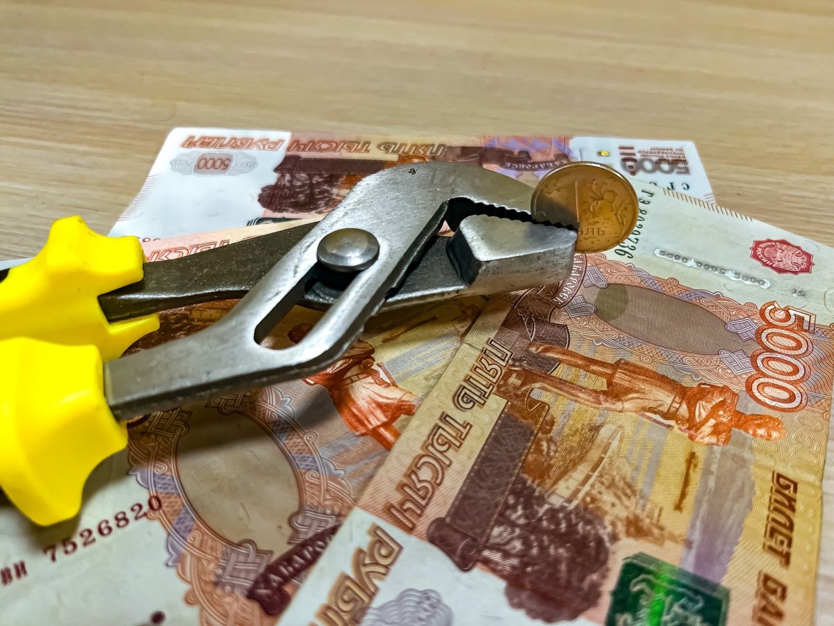 Пятитысячные купюры, разводной ключ и монета достоинством 1 рубль.