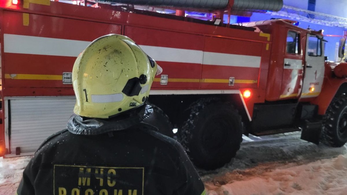 Огнеборец на фоне пожарной машины.