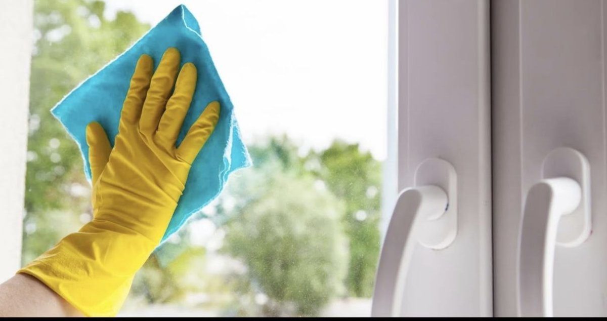 рука в перчатке моет окно