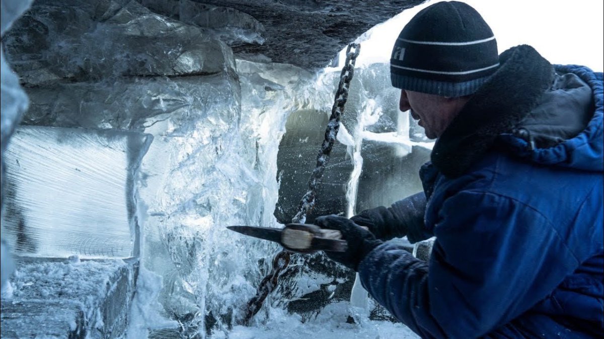 выморозчик работает кайлом под обшивкой днища танкера