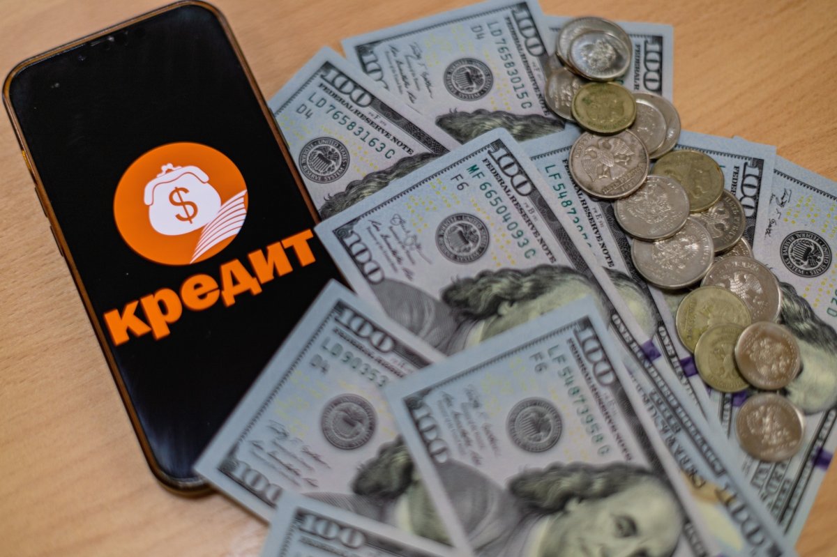 Телефон рядом с деньгами, взятыми в кредит.