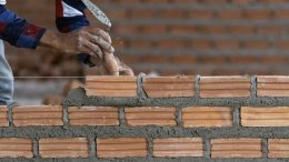 руки мастера укладывают кирпич