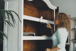 девушка красит кухонный буфет