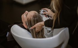 Женщина в салоне моет волосы