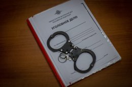 Наручники лежат на папке с уголовным делом