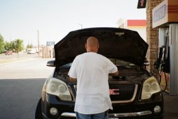 Мужчина смотрит в капот машины