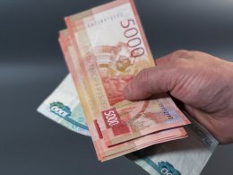 В руке несколько денежных купюр