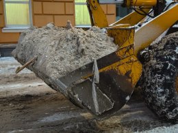 Экскаватор убирает снег в Мурманске