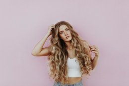 Девушка с длинными волосами на розовом фоне