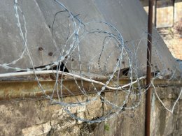 Колючая проволока на заборе.