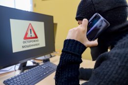 Мошенник разговаривает по телефону.