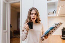 Девушка держит в руках газету и чашку с кофе