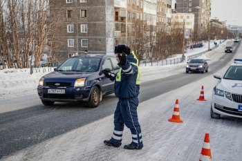 Сотрудник Госавтоинспекции останавливает автомобиль зимой