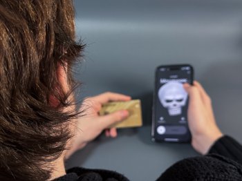 Человек диктует данные банковской карте мошеннику, звонящему на телефон