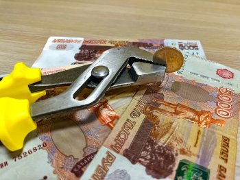 Пятитысячные купюры, разводной ключ и монета достоинством 1 рубль.