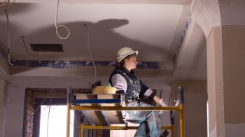 строитель на лесах