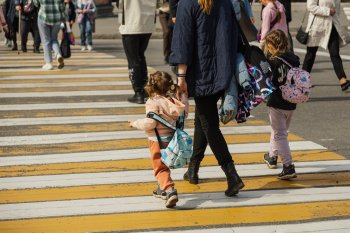 Мама с двумя дочками переходит дорогу по пешеходному переходу в Мурманске