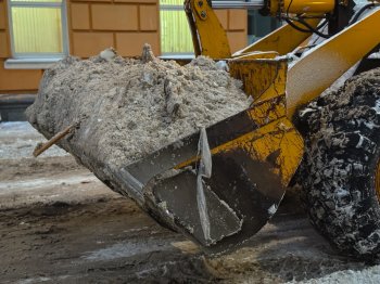 Экскаватор убирает снег в Мурманске