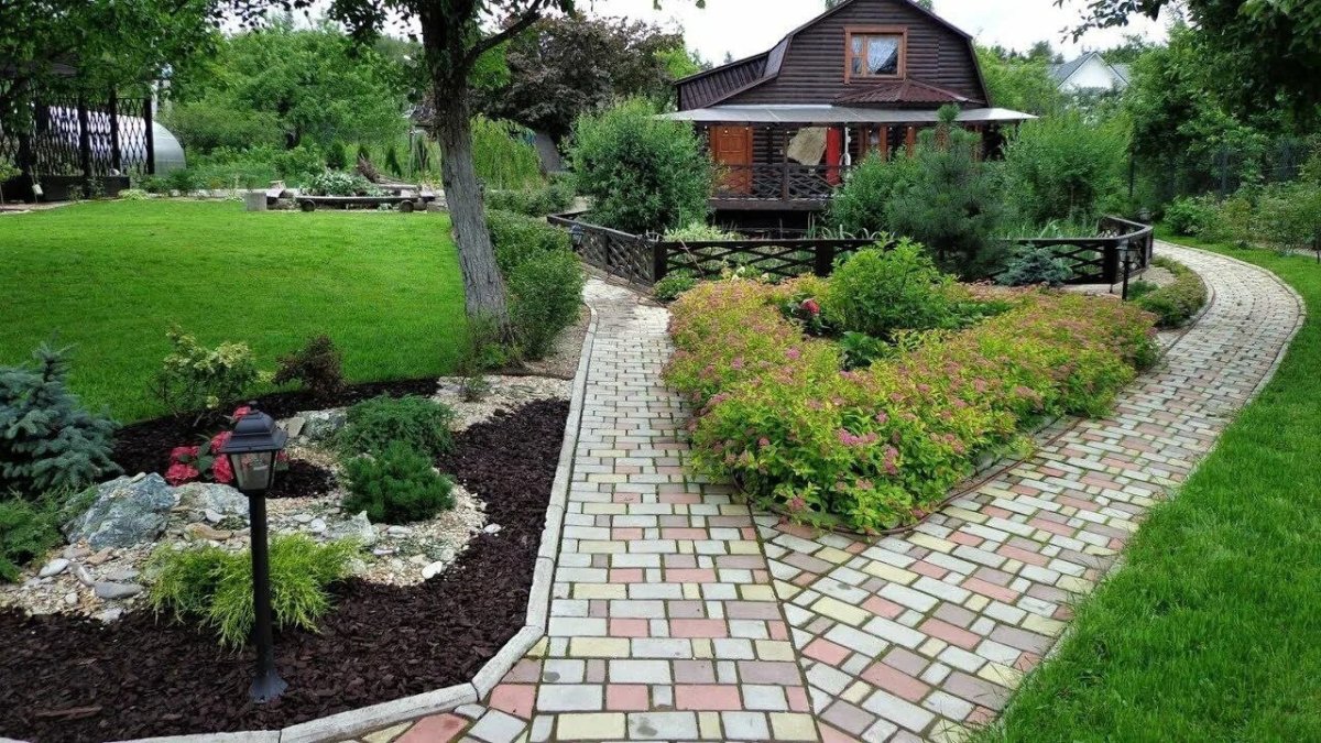 сад с клумбами и дорожкой из плитки