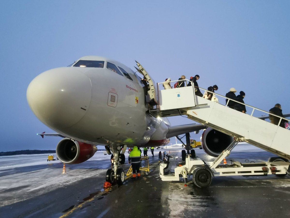 Пассажиры выходят из самолёта.
