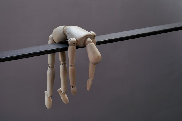 деревянная фигурка человека повисла на перекладине