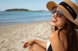 девушка в шляпе и темных очках на пляже