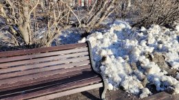 Кучка снега возле скамейки